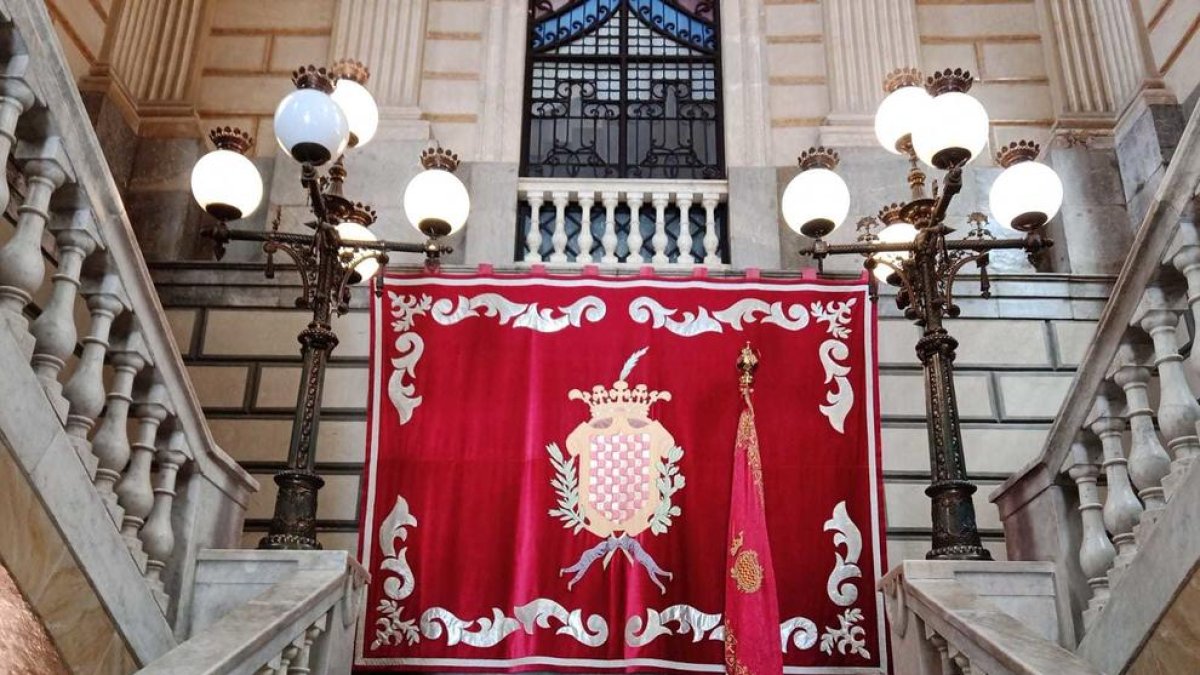 El domàs i la bandera de la ciutat presideixen les escales principals de l'Ajuntament de Tarragona.