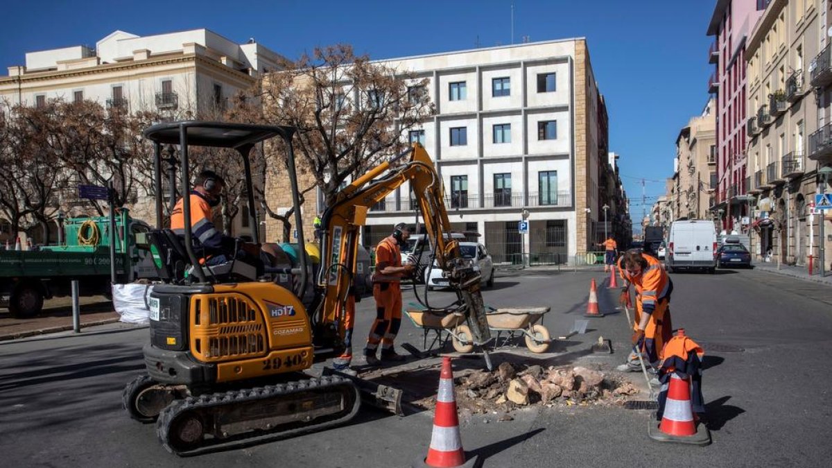 Un operari treient la rotonda de la plaça dels Carros.