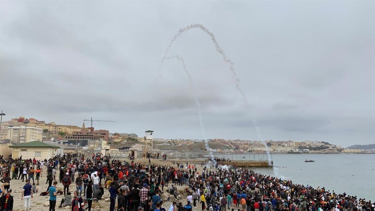Cientos de personas esperan en la playa de la localidad de Fnideq (Castillejos) para cruzar los espigones de Ceuta