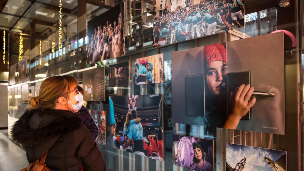 Una noia observa algunes de les fotografies que s'exposen al Mercat Central