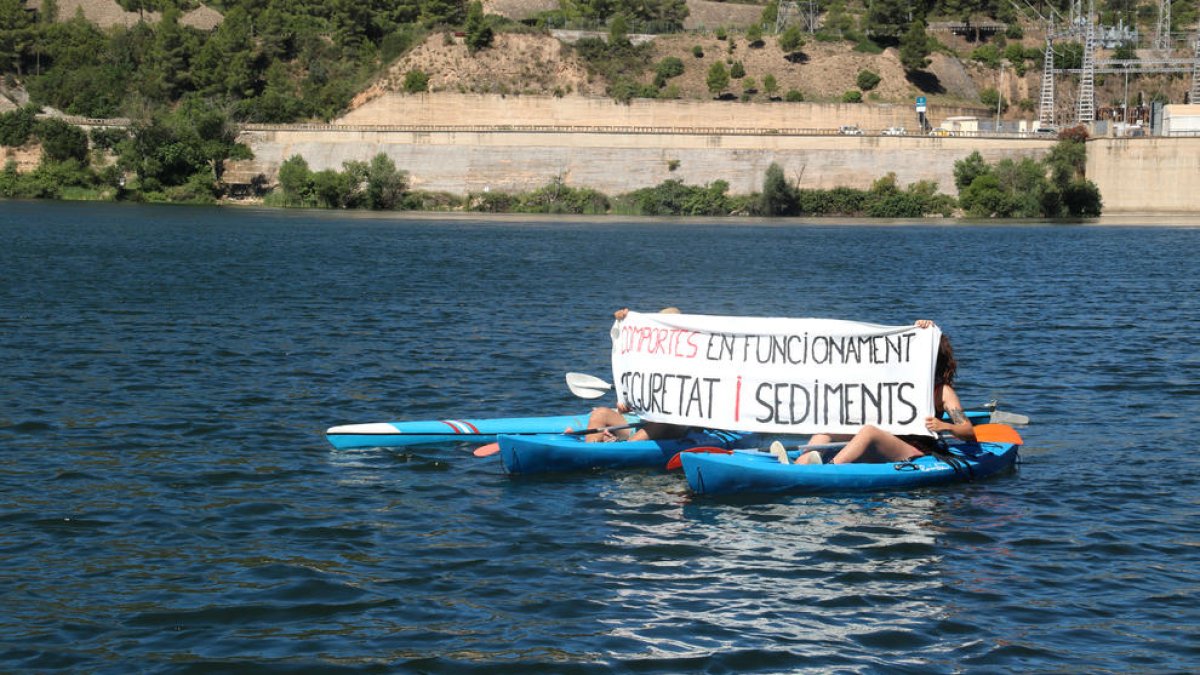 Pla general de dos participants a la Marxa dels Sediments desplegant una pancarta.