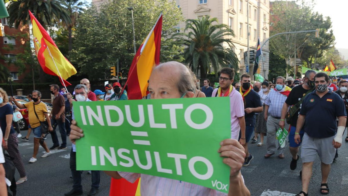 Un hombre muestra un cartel donde se lee 'indulto igual a insulto' durante una manifestación contra los indultos.