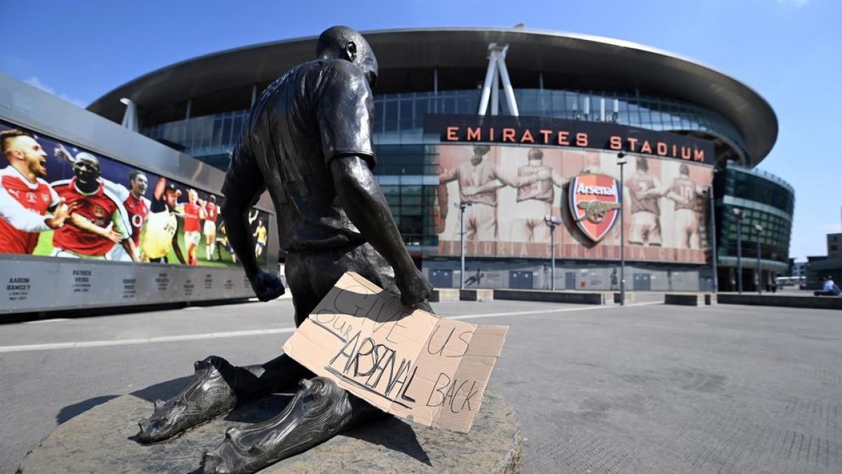 Un cartell amb el missatge 'Torneu-nos al nostre Arsenal' col·locat a les portes del Emirates Stadium del club.