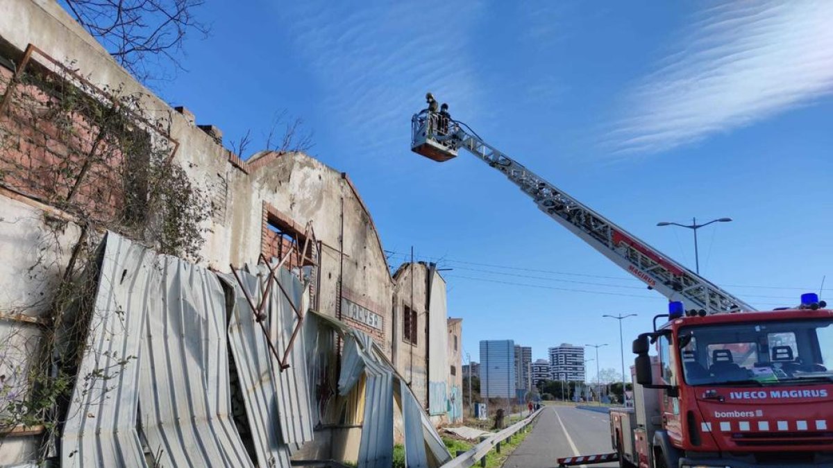 Els Bombers treballant per retirar ls planxes metàliques que obstaculitzaben la via.