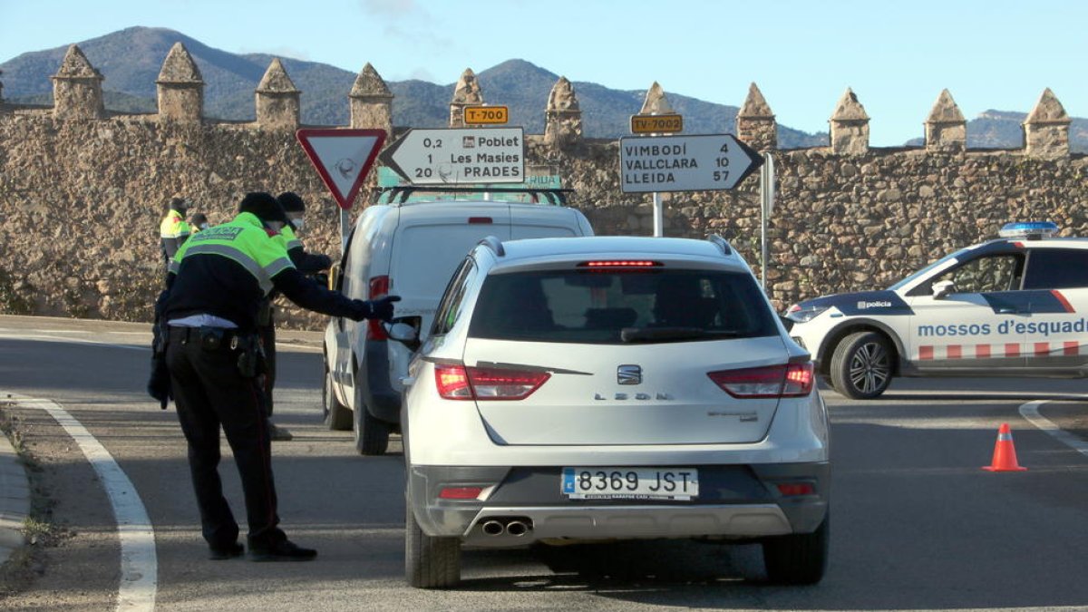 Agents de Mossos d'Esquadra aturant dos vehicles al control policial fet a la carretera T-700 al terme municipal de Vimbodí i Poblet.