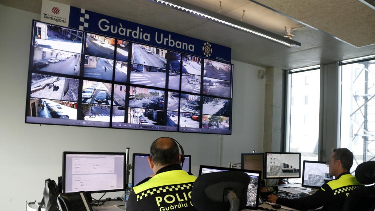 Dos agents de la Guàrdia Urbana de Tarragona treballant a la sala de control de la comissaria.