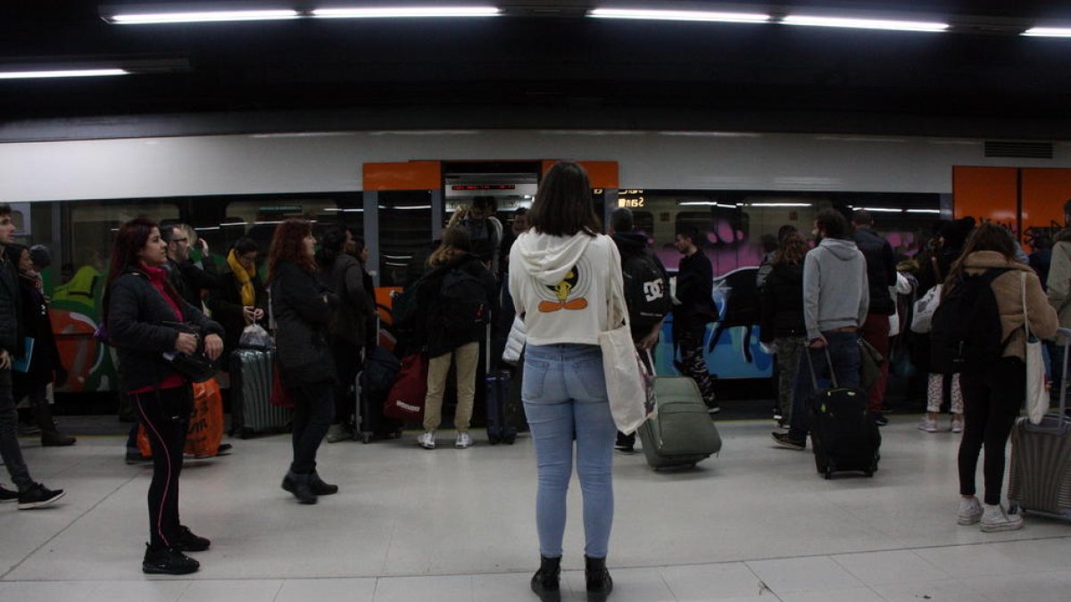 Pasajeros esperando para entrar al tren el dia de vaga general de Renfe.