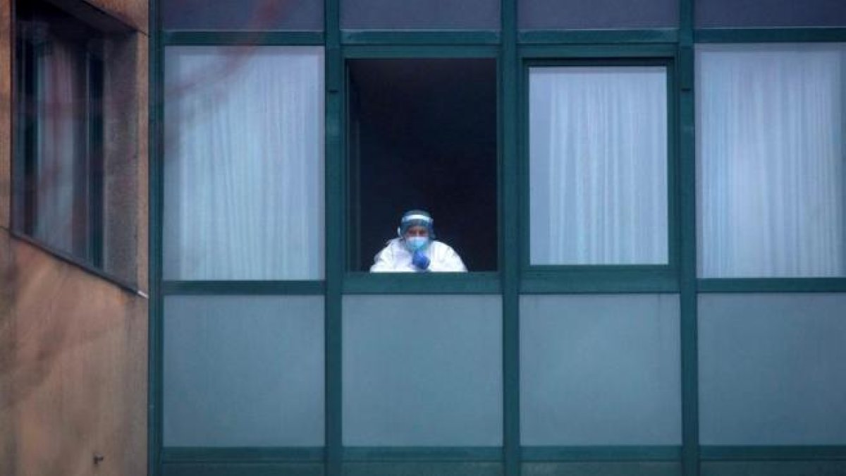 Una trabajadora sanitaria, en la ventana de una residencia de ancianos en Ourense.