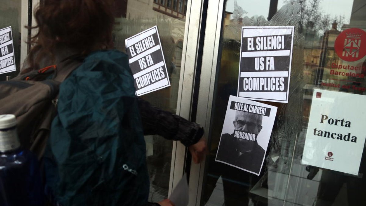 Alumnos del Institut del Teatre enganchan carteles en la puerta del centro para denunciar los presuntos casos de abuso de poder y acoso.