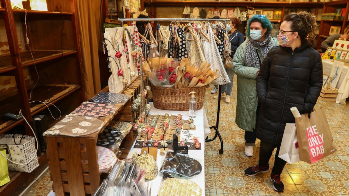 Dues dones mirant una parada al Navàs Market.