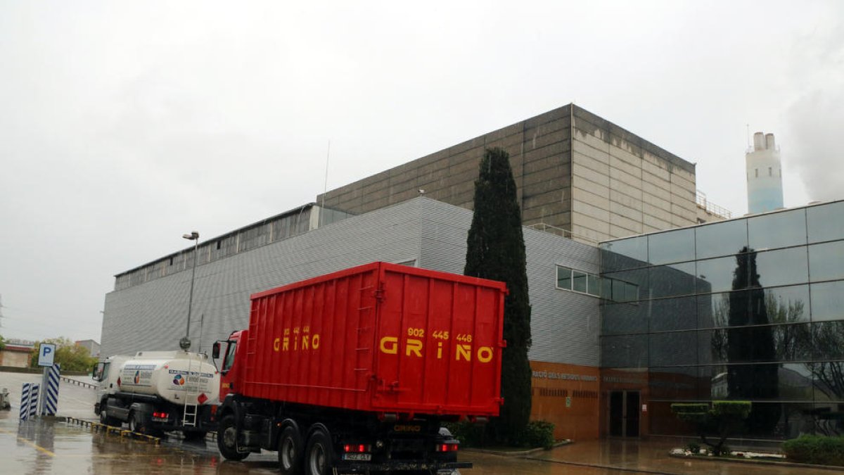 Plano general de un par de vehículos esperando para poder acceder al interior de la planta incineradora de Sirusa en Tarragona.