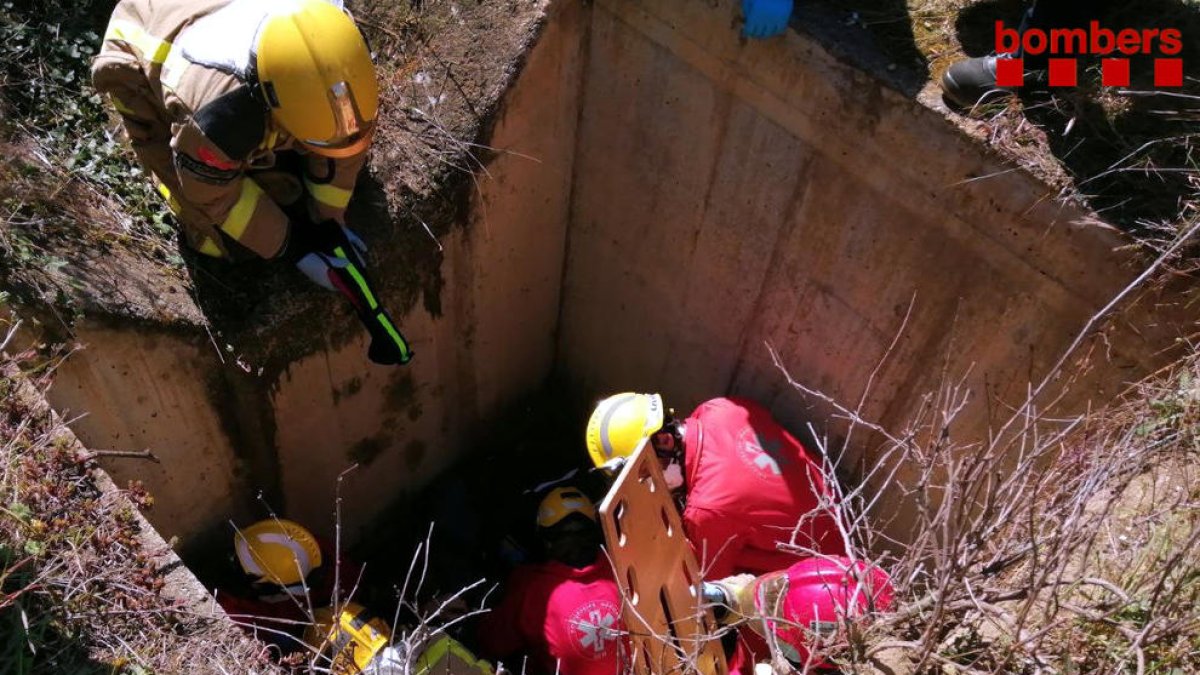 Els Bombers i el SEM trabajando en el pozo donde han caídos los dos motoristas.