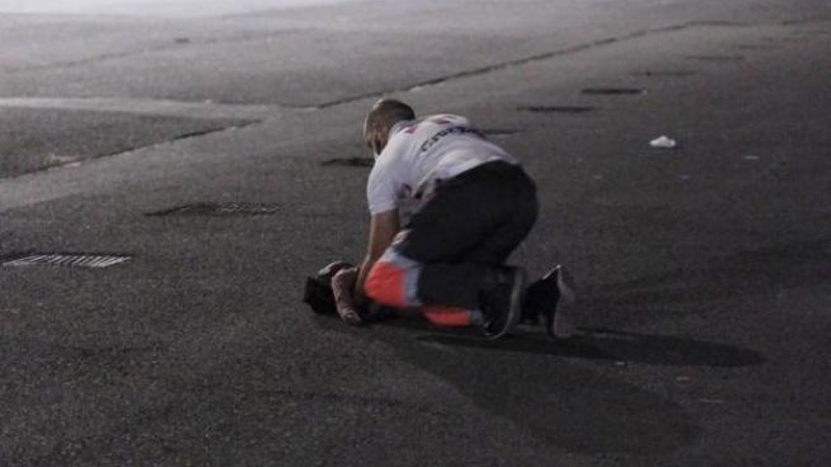 Imagen de un voluntario de la Cruz Roja tratando de recuperar a la niña al llegar a la isla.