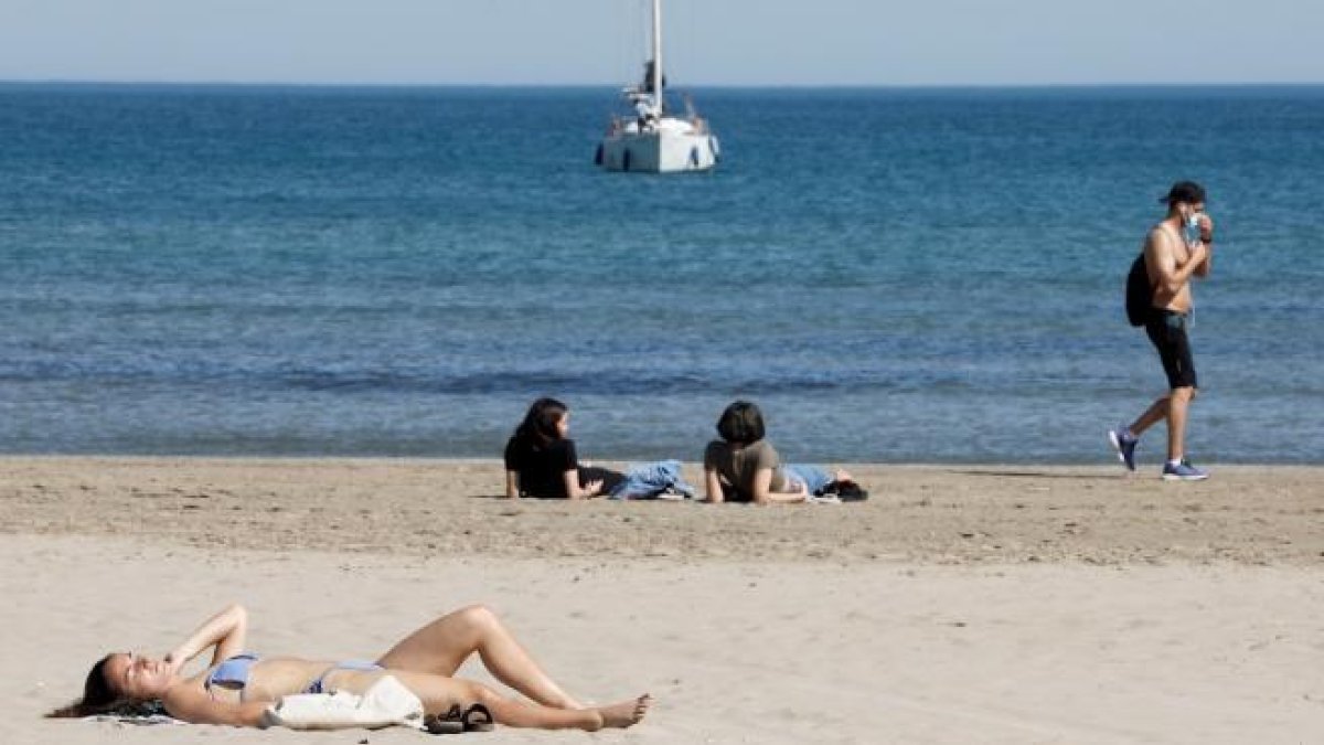 Varies persones prenent el sol a València.