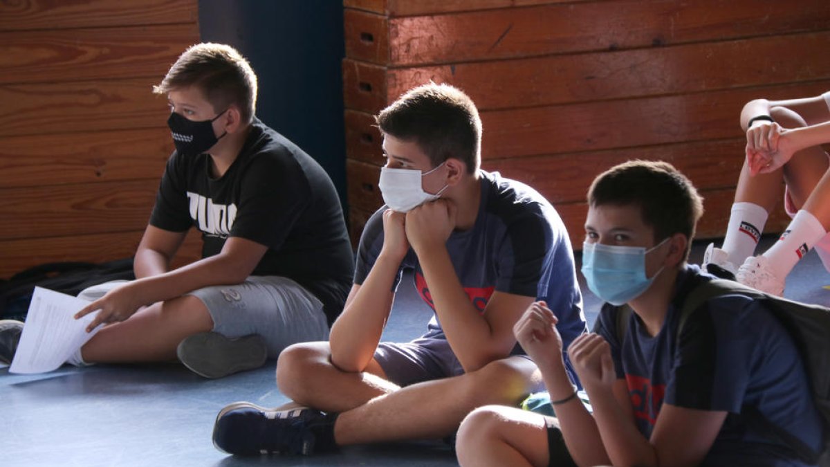 Varios alumnos con mascarilla en una clase.