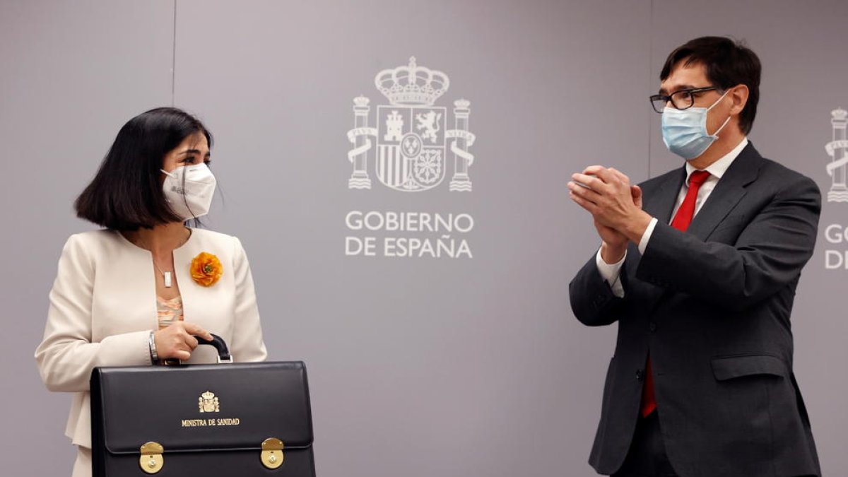 Carolina Darias cogiendo la cartera de ministra de Sanidad acompañada de Salvador Illa.