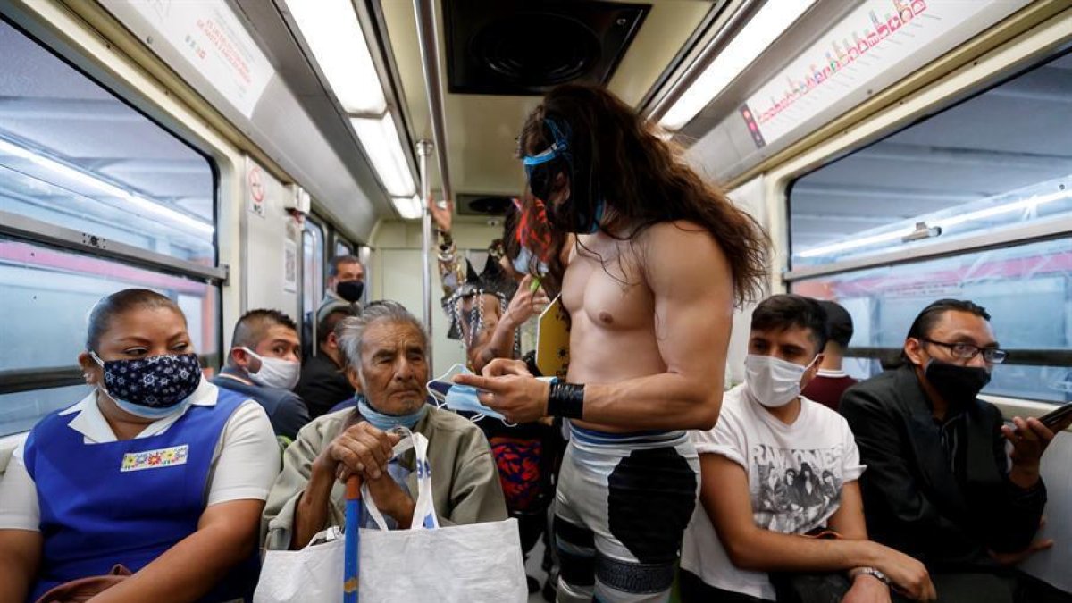 Profesionales de la lucha libre mexicana viajan concienciando del uso de mascarillas y regalándolas.