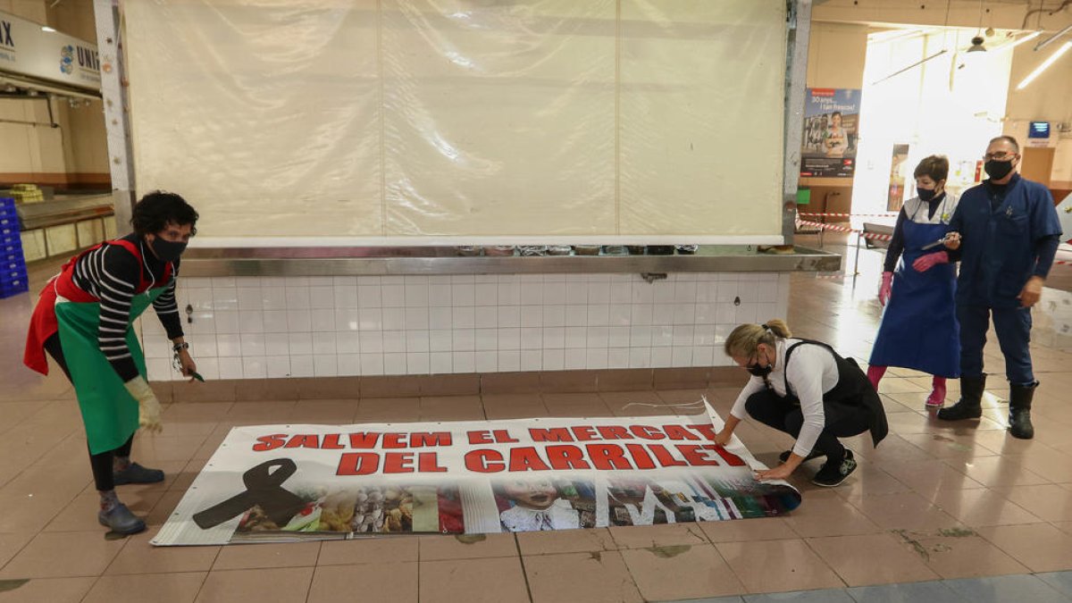 Els venedors van despenjar ahir la pancarta de 'Salvem el mercat del carrilet'.