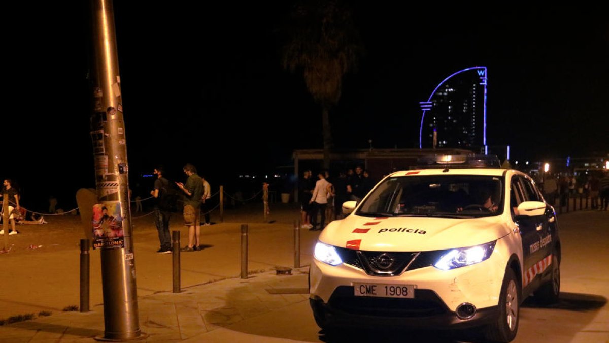 Un cotxe dels Mossos patrulla per la Barceloneta poc abans del toc de queda.