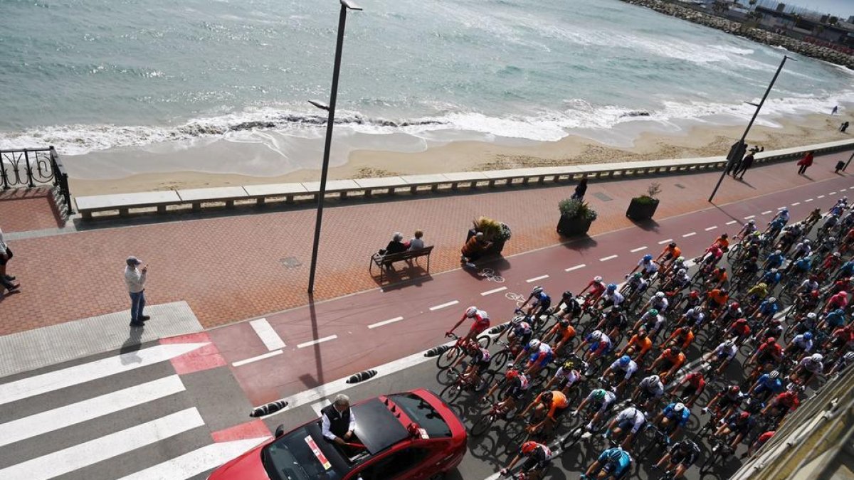 Los ciclistas pasando por el paseo marítimo.