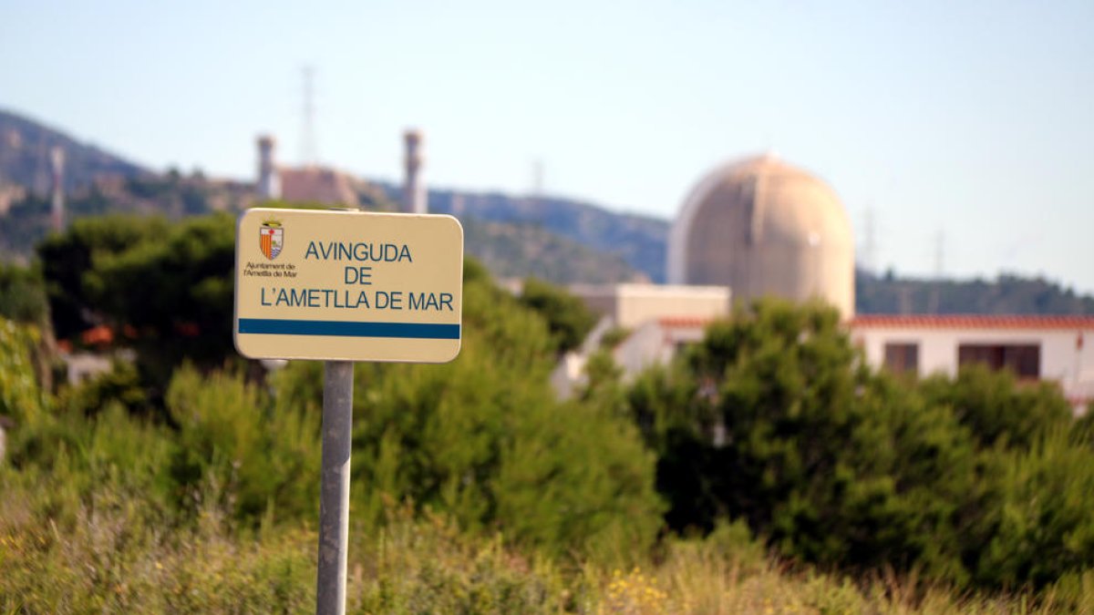 Un cartell amb el nom d'un carrer a l'Ametlla de Mar (Baix Ebre) amb la central nuclear de Vandellòs.