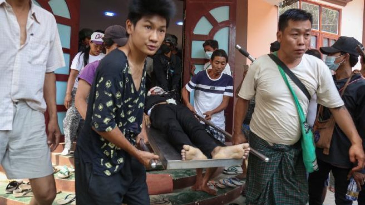El cuerpo de un joven de 18 años que recibió un disparo en la cabeza es transportado durante los disturbios en Birmania (Myanmar).