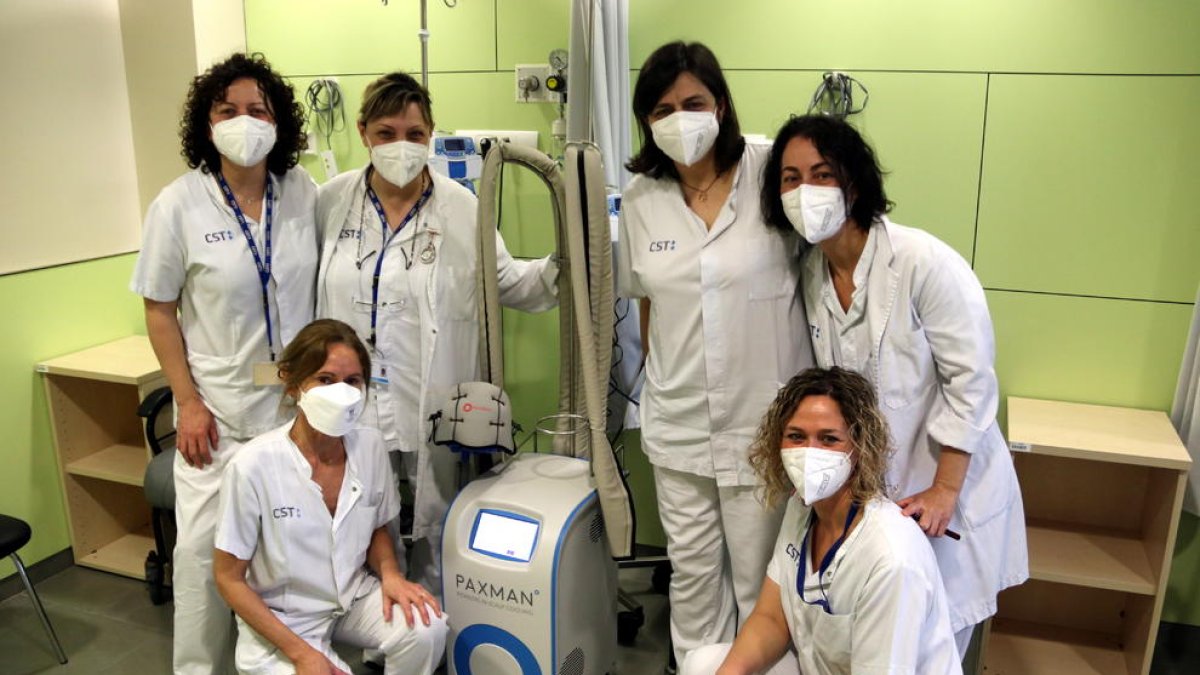 Foto de grup de l'equip d'infermeria d'hospital de dia d'oncologia de l'Hospital de Terrassa amb el dispositiu per prevenir l'alopècia.