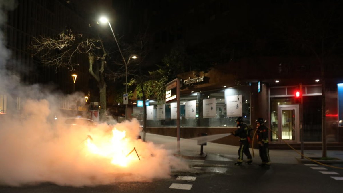 Els Bombers apagant una de les barricades que s'han fet a Barcelona durant els aldarulls.