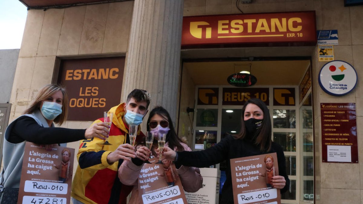 Brindis davant l'estanc 'Les Oques' de Reus, amb la comercial de Loteries de Catalunya, la premiada Laia Navarro amb el 3r premi de la Grossa i la seva parella, i la responsable de l'estanc, Lara Martínez.