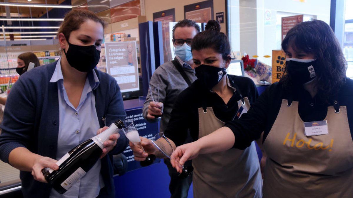 Pla conjunt d'un grup de treballadores del supermercat Bonpreu i Esclat de Tortosa celebrant el tercer premi de la Grossa de Cap d'Any.