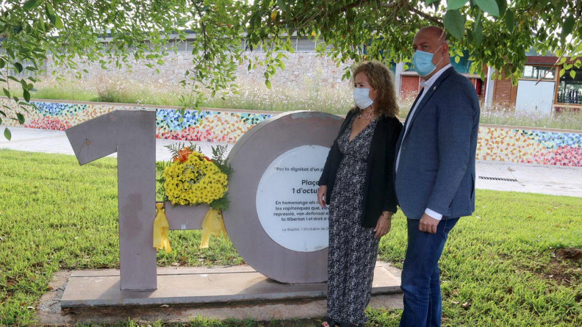 Plano entero del alcalde de la Ràpita, Josep Caparrós, y la coordinadora local de la ANC, Mariona Gairí, durante la ofrenda floral en el monolito conmemorativo del 1-O.