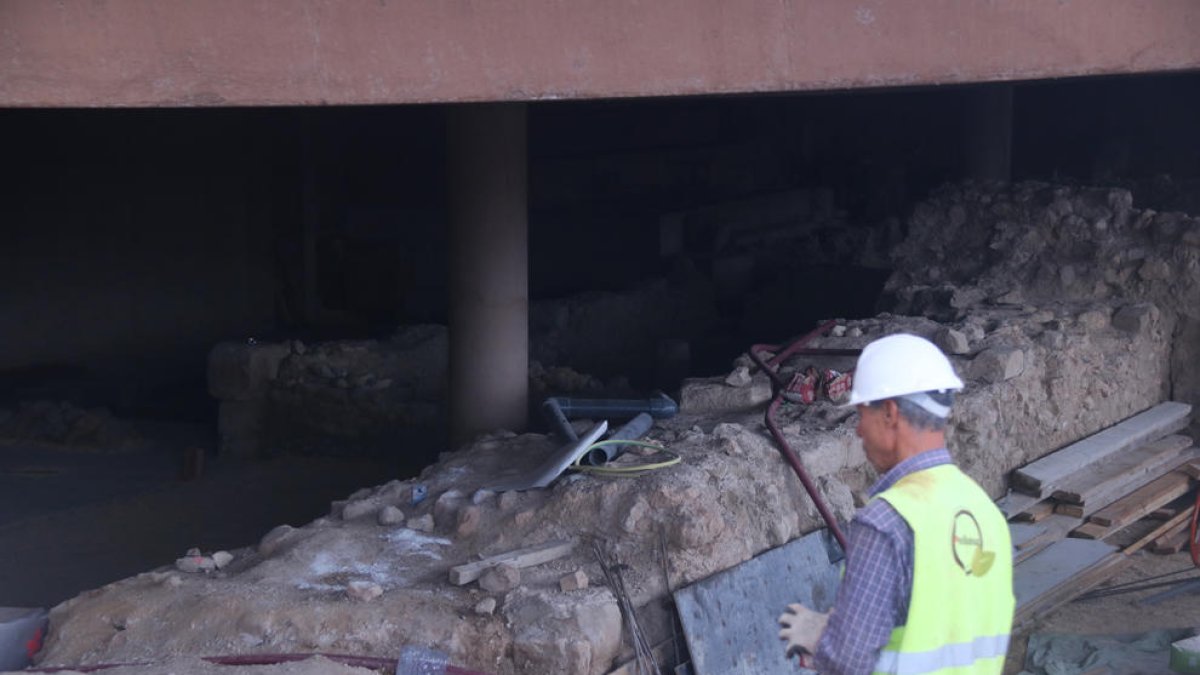 Pla mitjà d'un operari treballant a les restes arqueològiques que han aparegut a la plaça de la façana de la catedral de Tortosa.