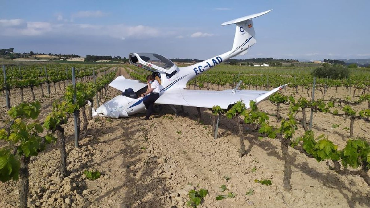 Pla general de l'avioneta del CESDA i del pilot parlant per telèfon damunt d'una ala.