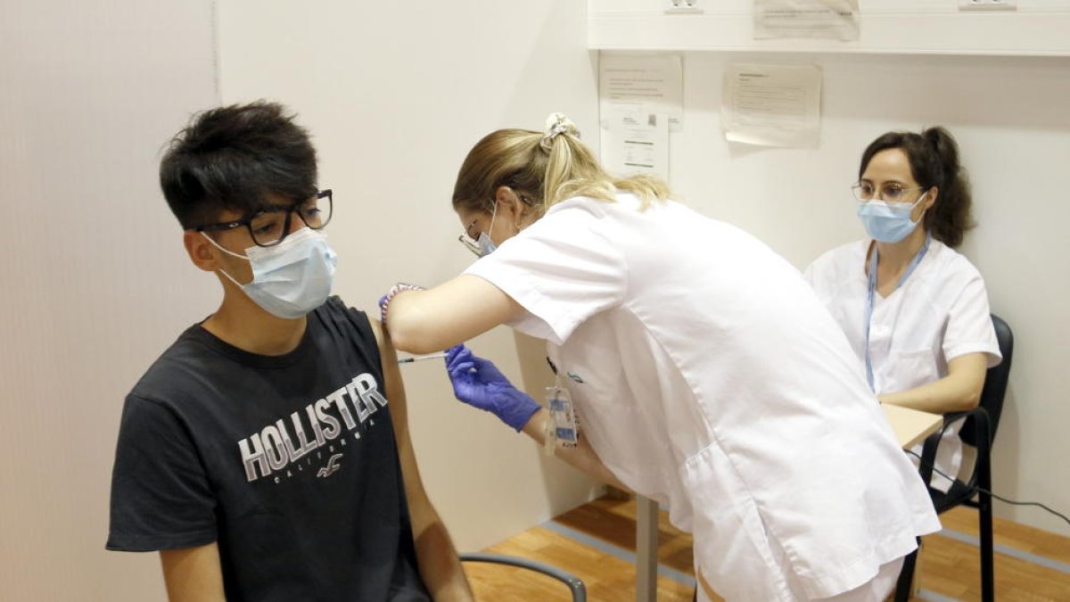 Un jove de 17 anys rebent una dosi de vacuna anticovid.