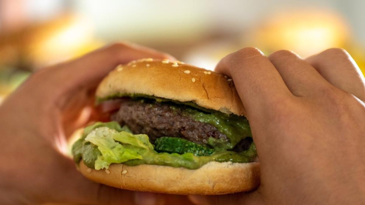 Imagen de archivo de una persona comiéndose una hamburguesa.