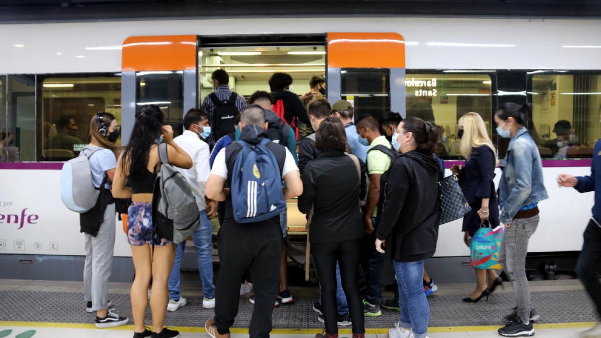 Un nombrós grup de gent intenta entrar a un tren en la segona jornada de vaga de maquinistes de Renfe a l'estació de Barcelona-Sants.