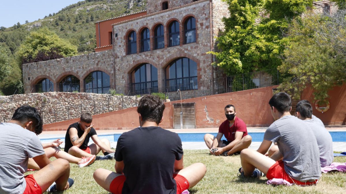 Unos menores haciendo estiramientos a los jardines de un centro terapéutico para adolescentes, del grupo Amalgama7, ubicado en el Alt Camp.