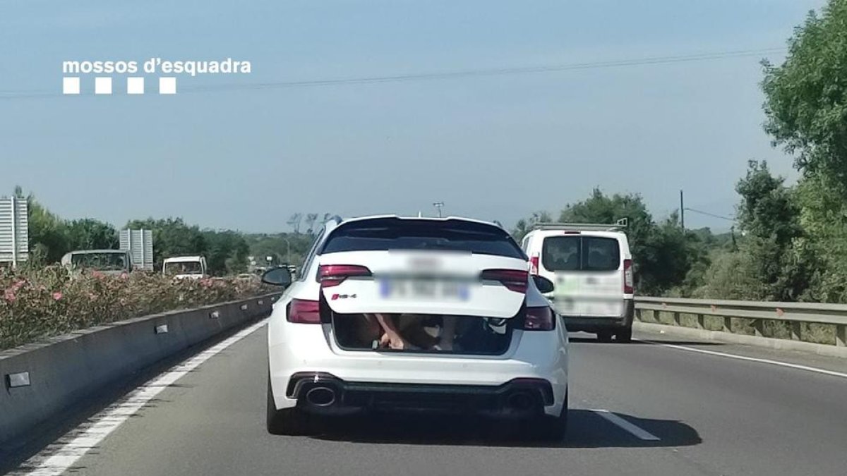 El cotxe amb el maleter mig obert i els dos nens a l'interior circulant per la C-260 a l'alçada de Castelló d'Empúries