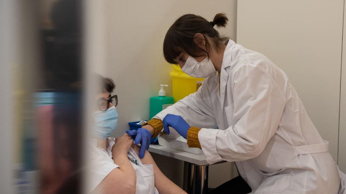 Una professional de l'Hospital Clínic rep la tercera dosi de la vacuna contra la covid-19.