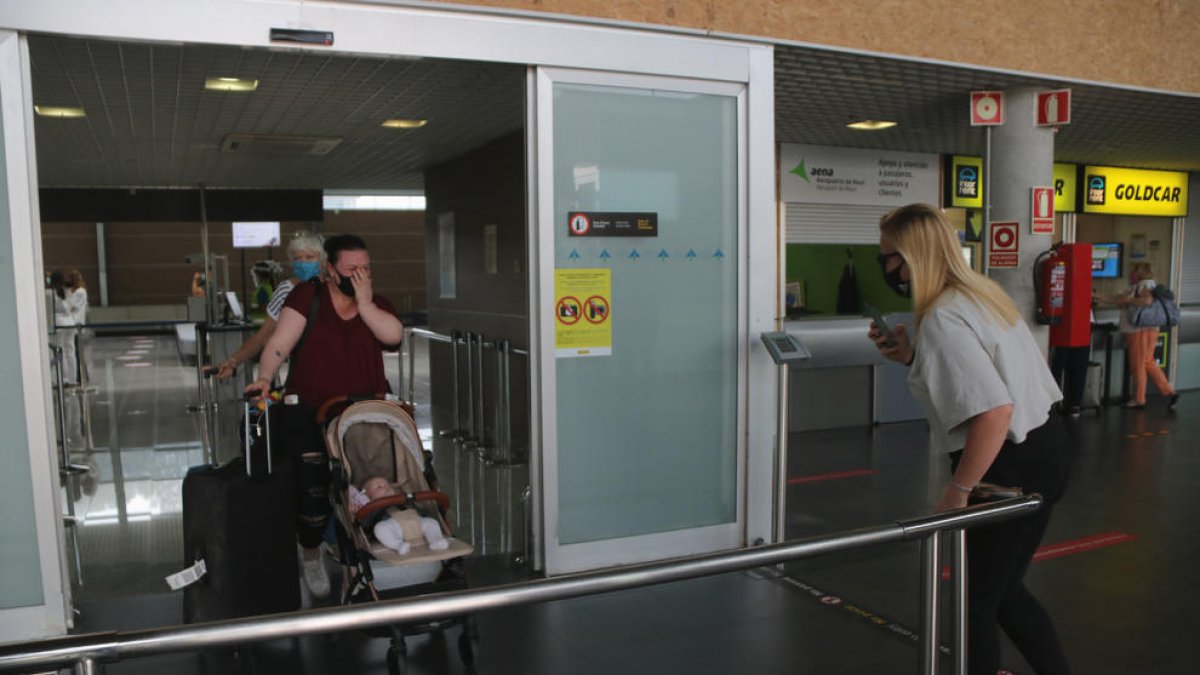 Pla obert d'una família que coneix per primera vegada la seva fillola, aquest dimarts al migdia a la Terminal d'arribades de l'Aeroport de Reus.