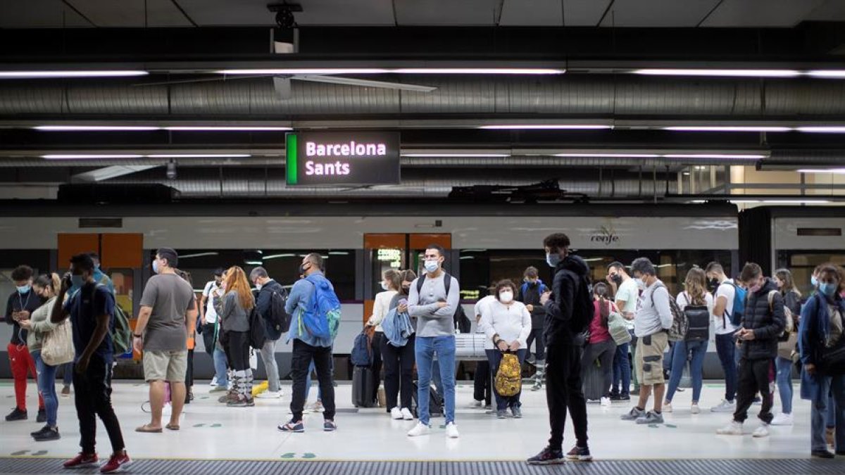 Usuarios de Renfe esperando en los andenes de la estación de Sants en Barcelona.