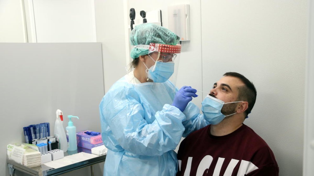 Una infermera fent un test d'antígens a un pacient.