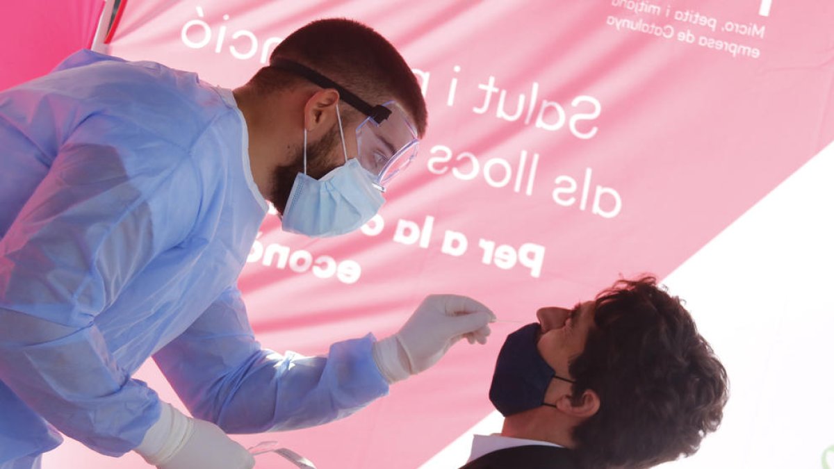 Personal sanitari pren mostres a un treballador del polígon de Sant Quirze del Vallès per fer un test d'antígens.