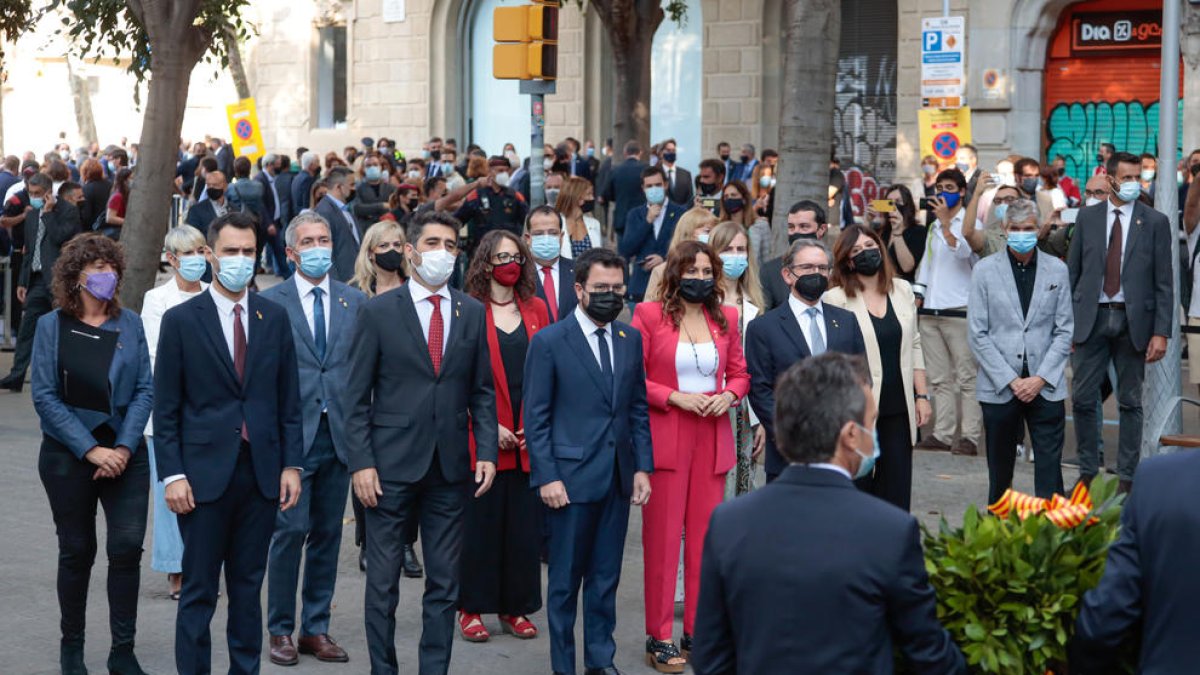 El Govern de la Generalitat, encabezado por el presidente Aragonès, mirando como colocan la ofrenda floral en el monumento de Rafael Casanova.