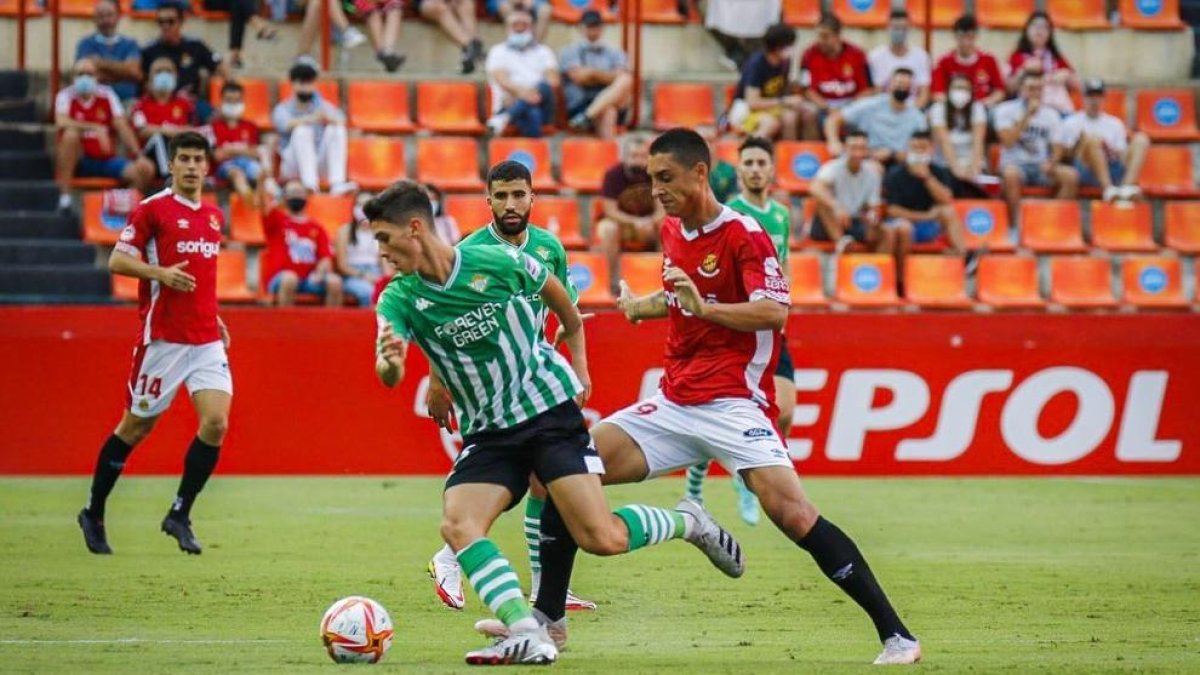 Pablo Fernández luchando una pelota contra un defensor del Betis.