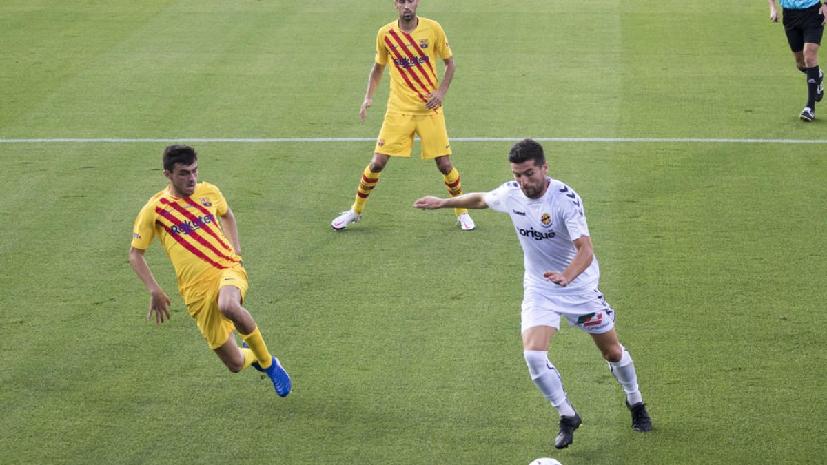Javi Bonilla, durant el Barça-Nàstic de la temporada passada, amb l'oposició de Pedri i sota l'atenta mirada de Sergio Busquets.