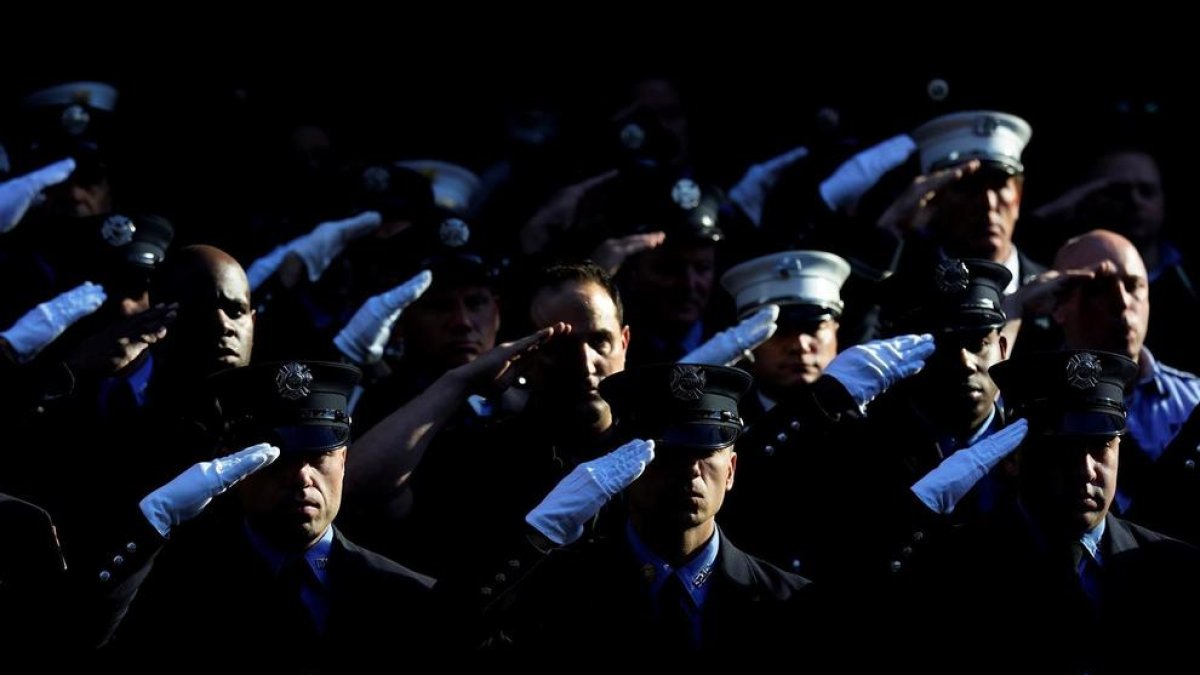 Integrantes del Departamento de Bomberos de Nueva York guardan un minuto de silencio en honor a los fallecidos durante el 11 de septiembre de 2021, este sábado en Nueva York