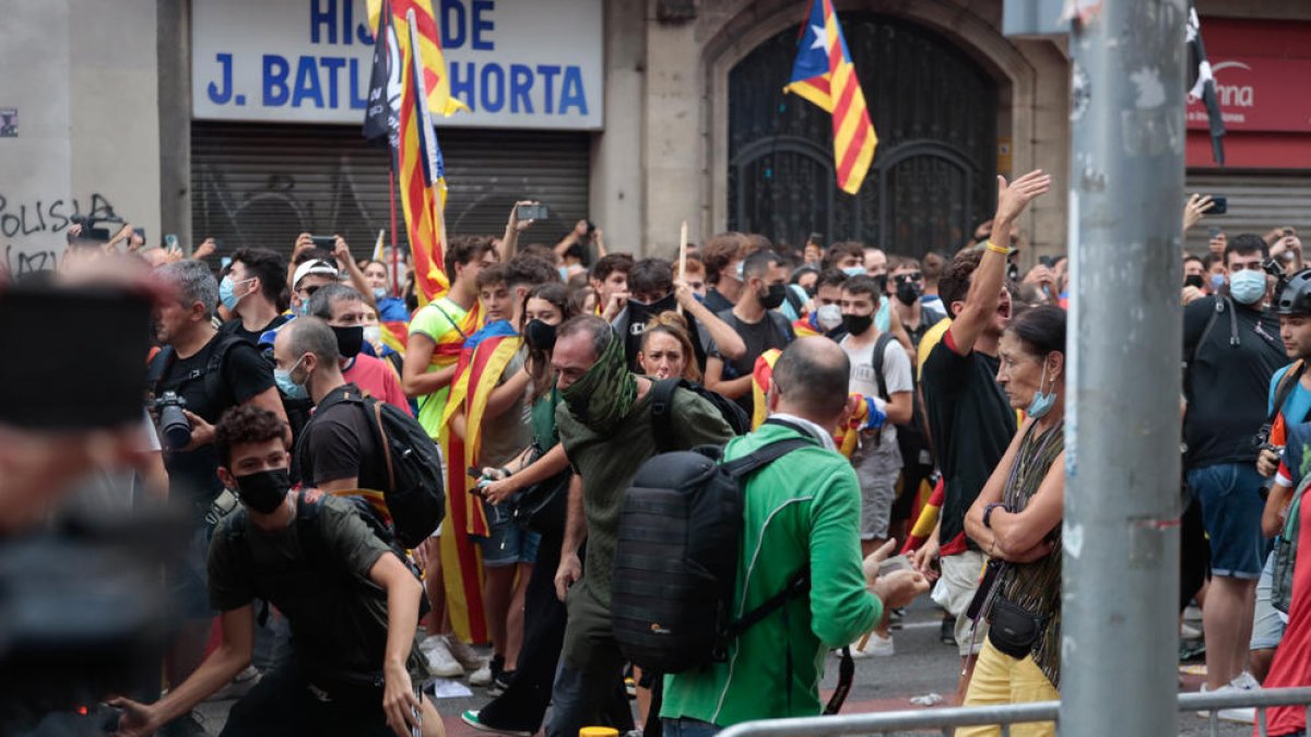 Un jove es prepara per llançar un objecte a la Via Laietana de Barcelona l'11 de setembre de 2021.