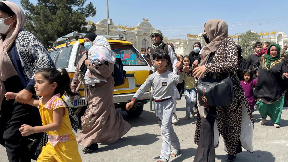 Mujeres con sus hijos intentan llegar al aeropuerto Hamid Karzai de Kabul.