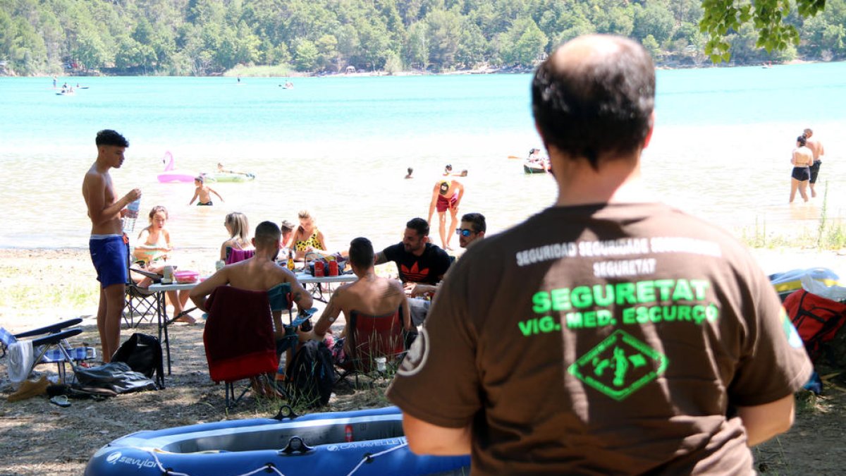 El pantano de Sant Ponç, lleno de bañistas. En primer término, un vigilante privado.